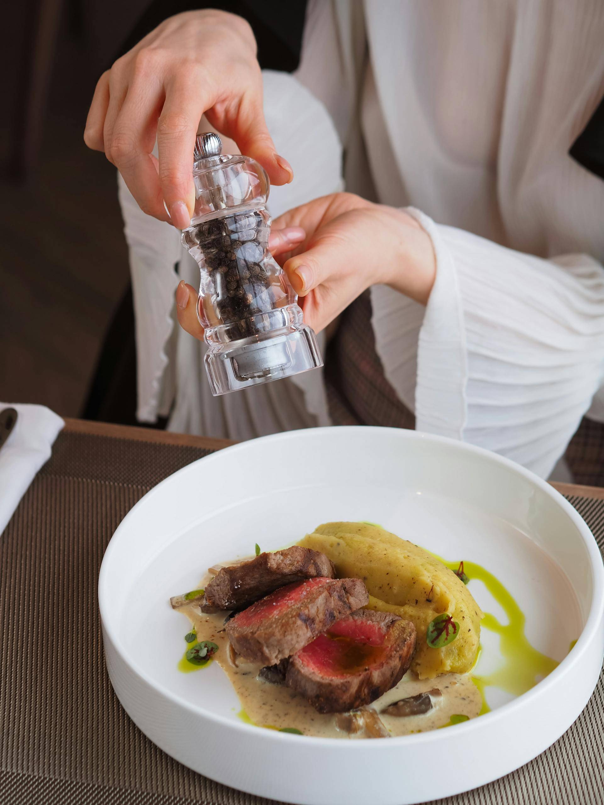 Woman Adding Spices to her Meal 